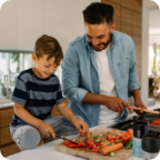 A father and son prepare dinner together. 